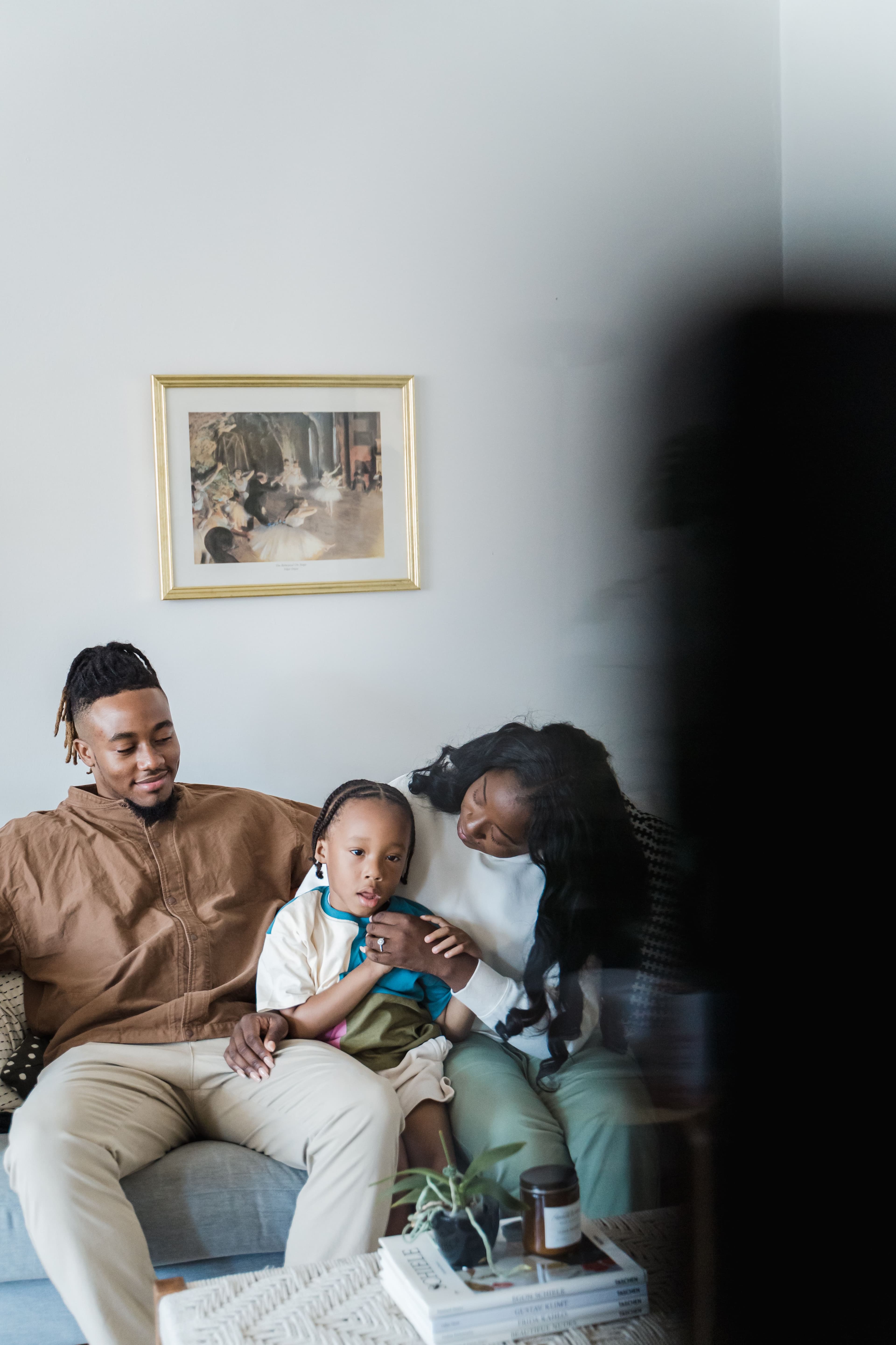 Family relaxing together on a sofa in a bright living room.